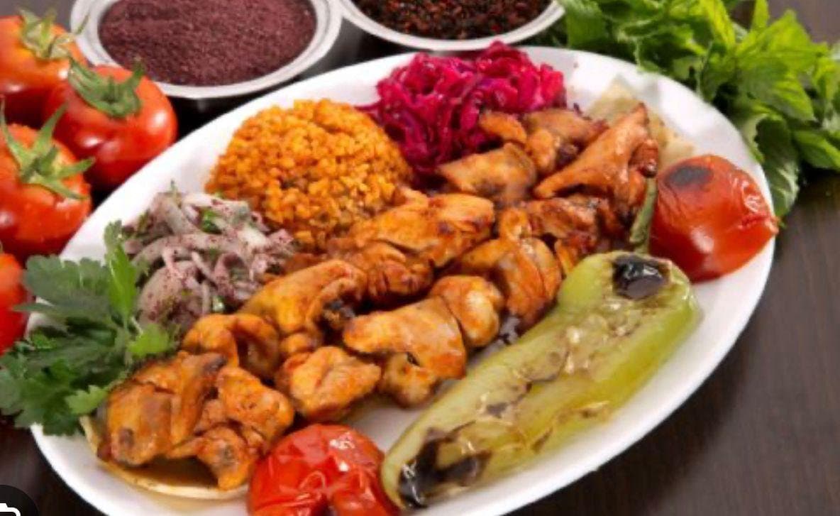 Marinated chicken with bulgur pilaf, grilled pepper and tomato