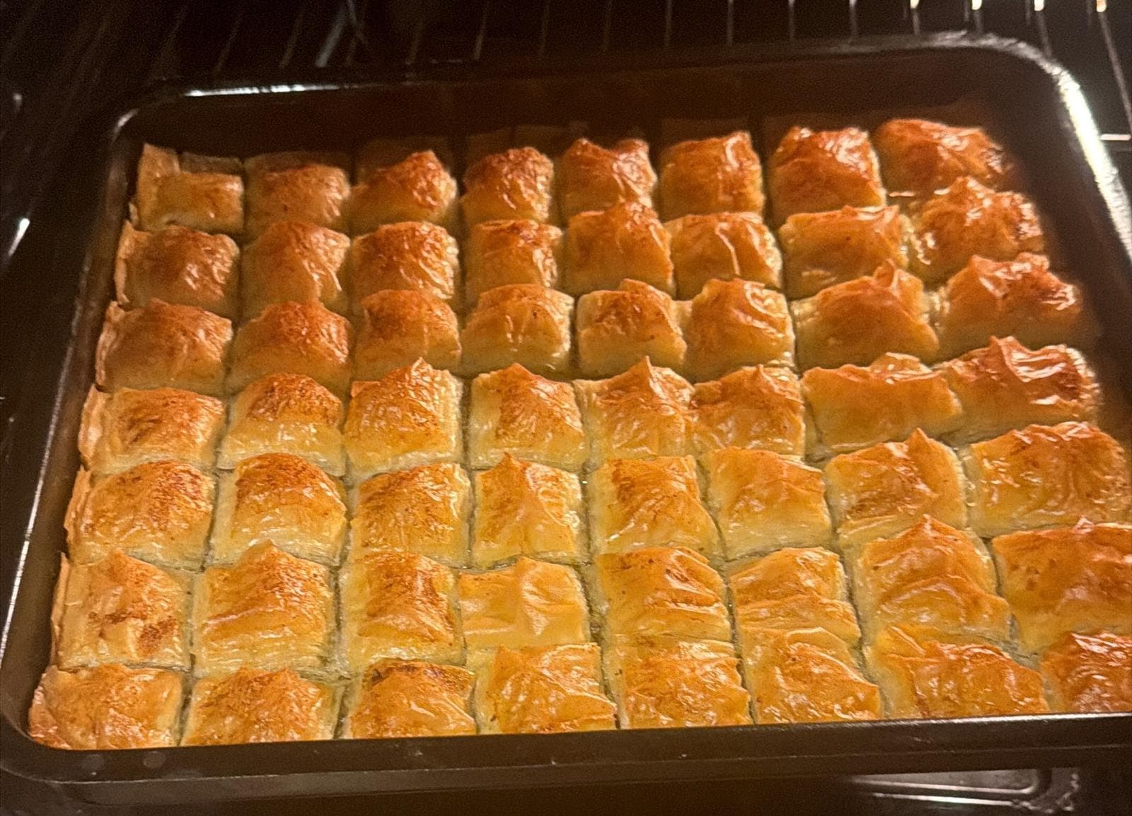 Tray of golden pistachio baklava fresh from the oven