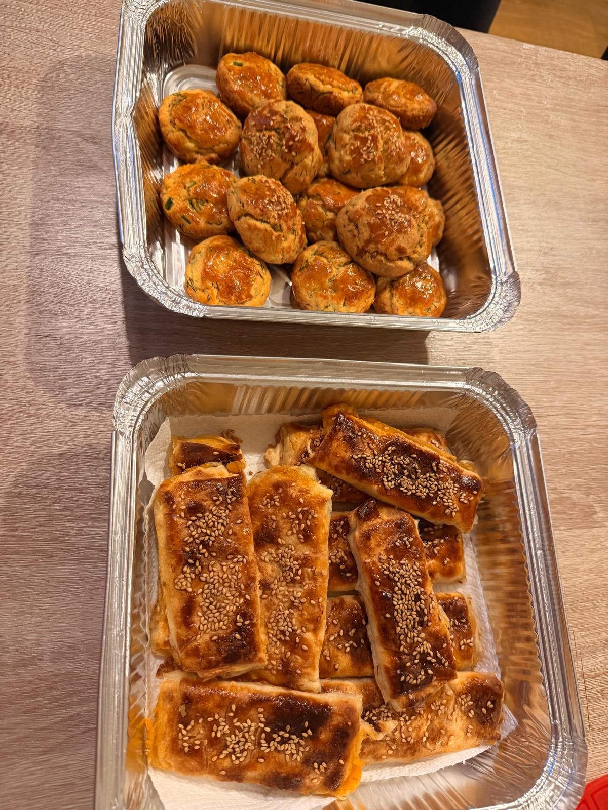 Foil trays of baked Turkish pastries with potato and cheese