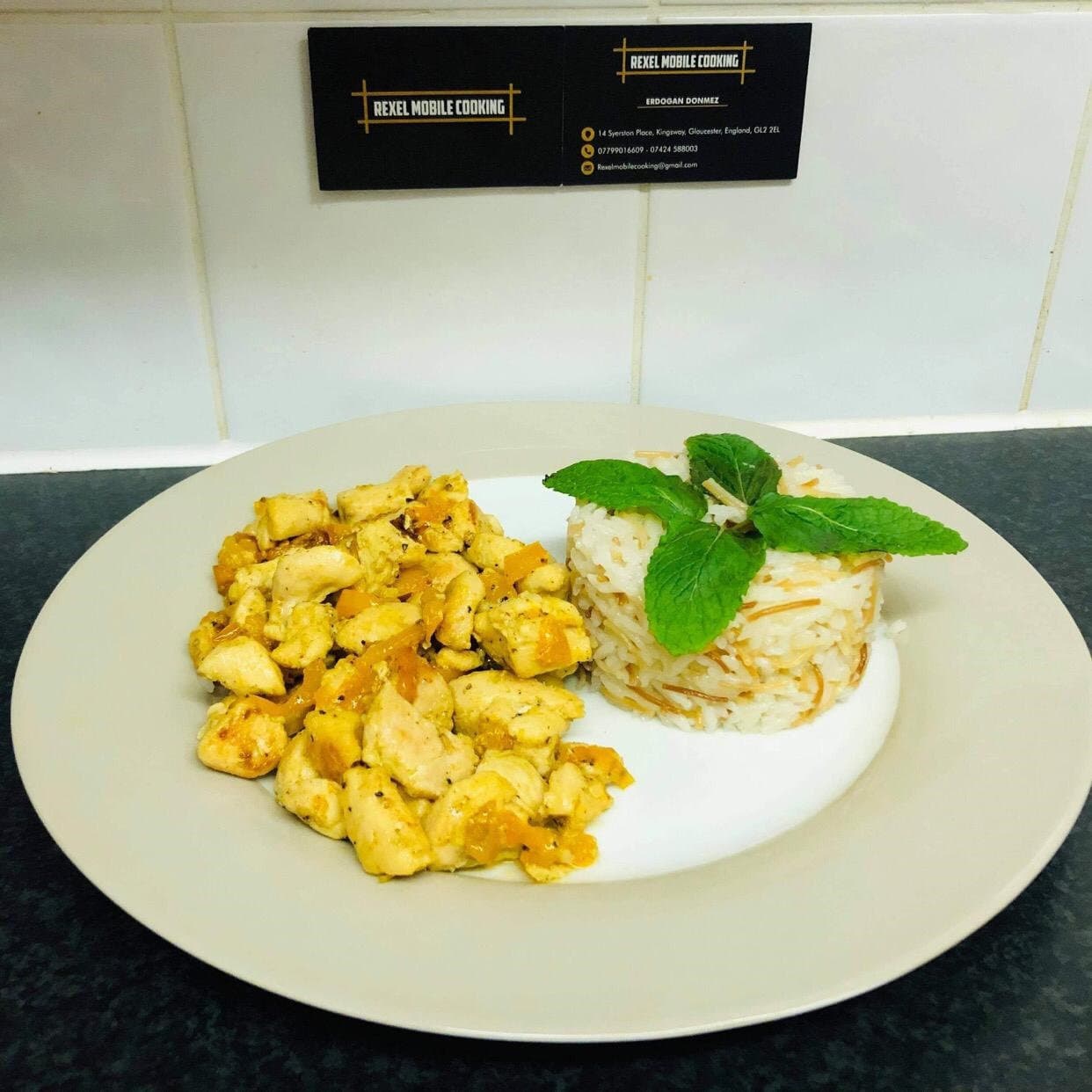 Plated chicken with rice and fresh mint, with Rexel Mobile Cooking business cards